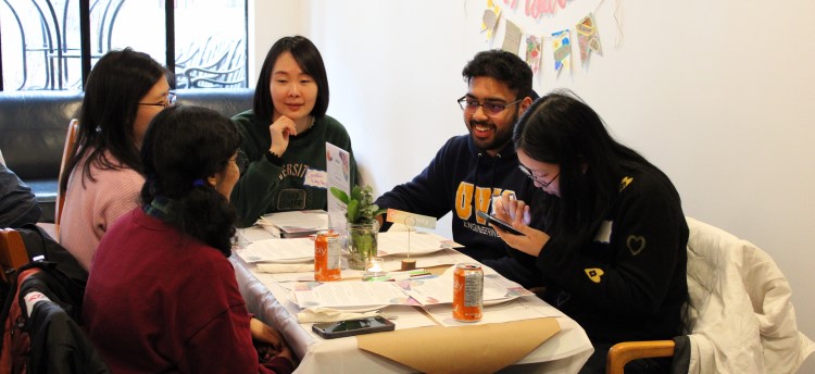 Five students sitting at a table talking at a Nourish+Flourish event