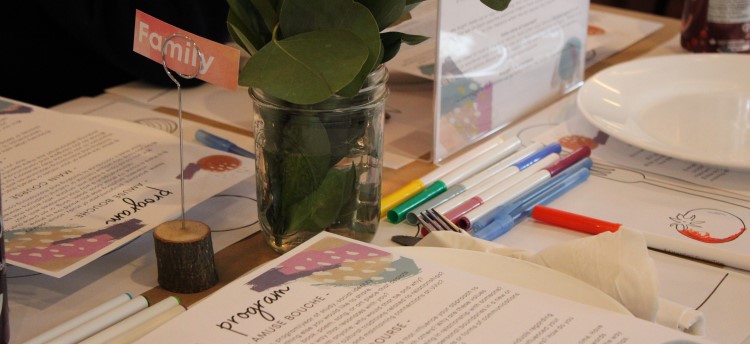 A closeup of a place setting and printed program at a Nourish+Flourish event