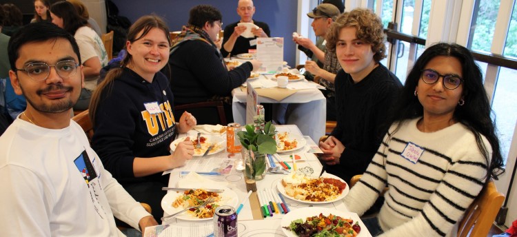 Four students sitting around a table at a Nourish+Flourish event
