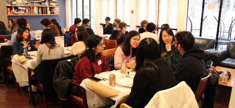 Students sitting at different tables and talking to eachother at a Nourish+Flourish event