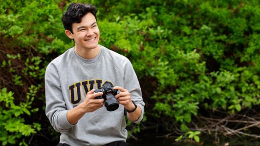 UVic student Devin Owpaluk holds a camera during his professional communications internship with IACE.