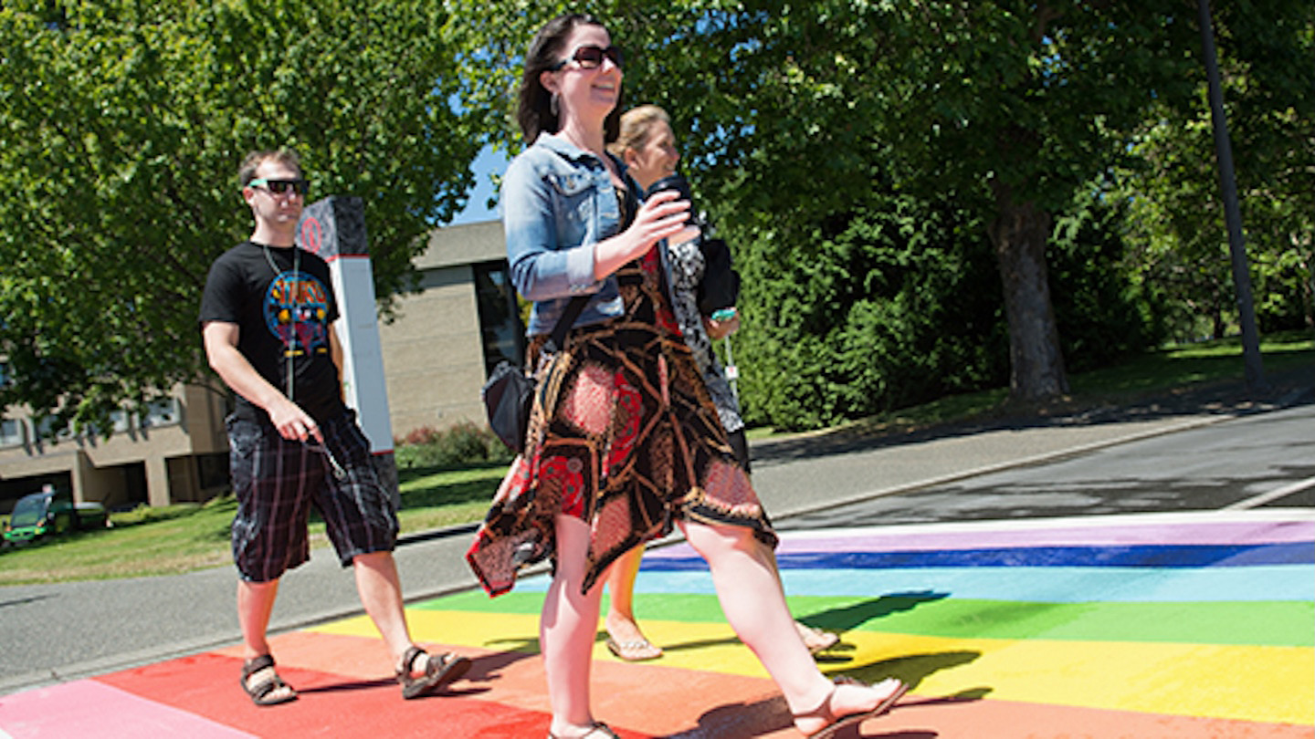 students walking across rainbow crosswalk