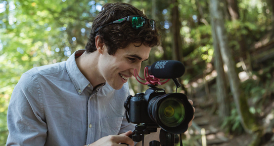 Levi Hildebrand behind a video camera outdoors