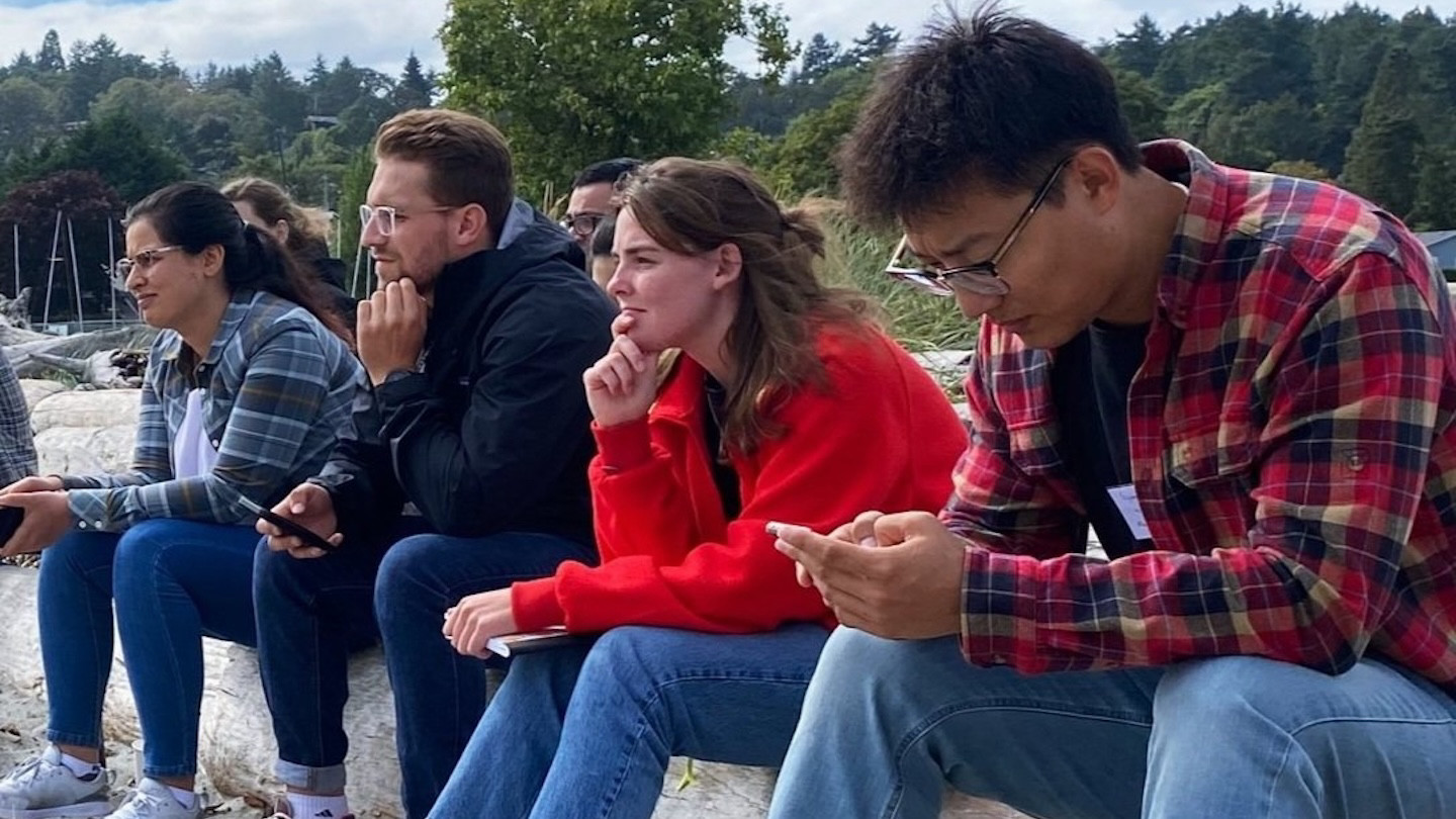students sitting at the beach