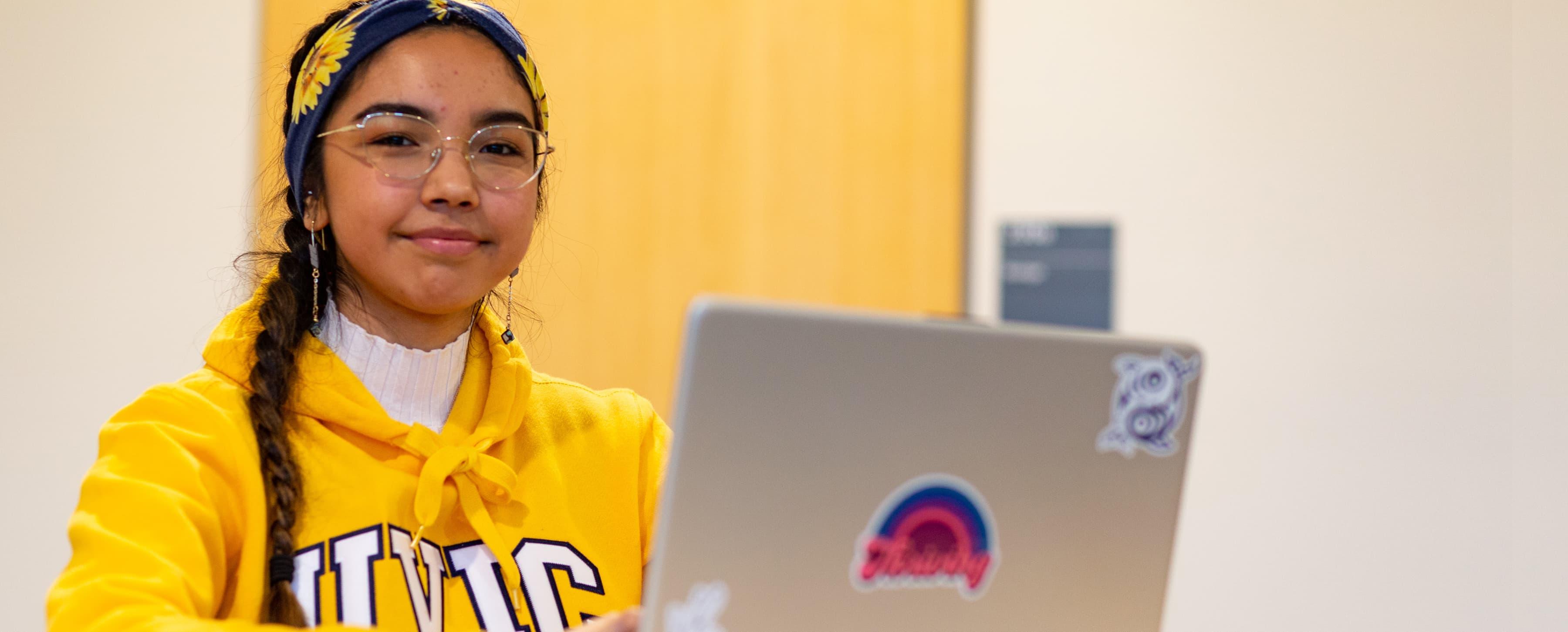 smiling student sitting with laptop