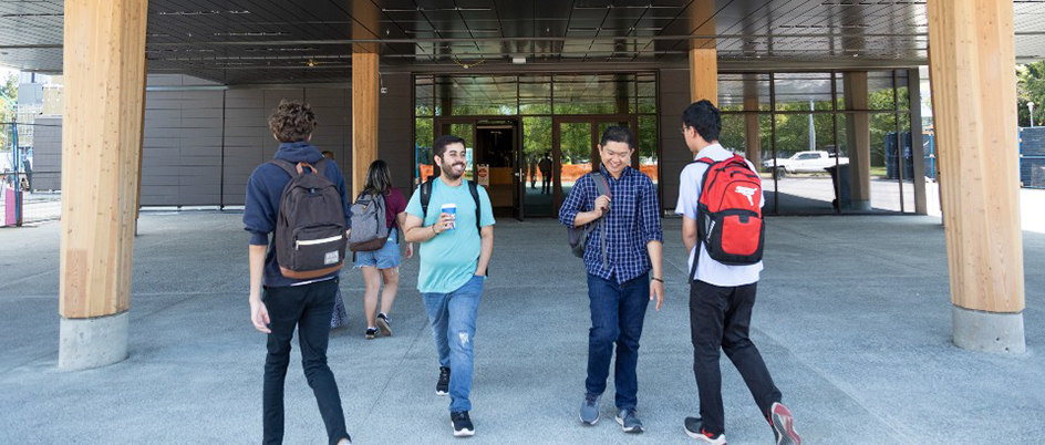 students walk in front of the entrance to building one