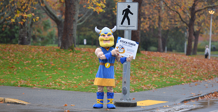 UVic Thunder holds a stocktober sign and waves at the camera