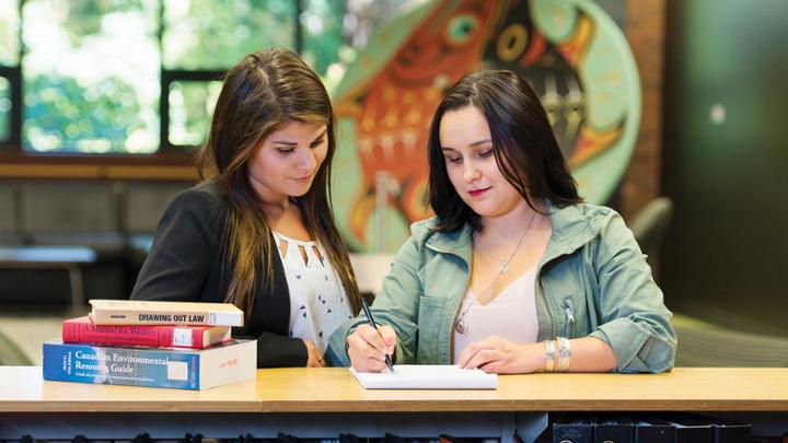 two students referencing book