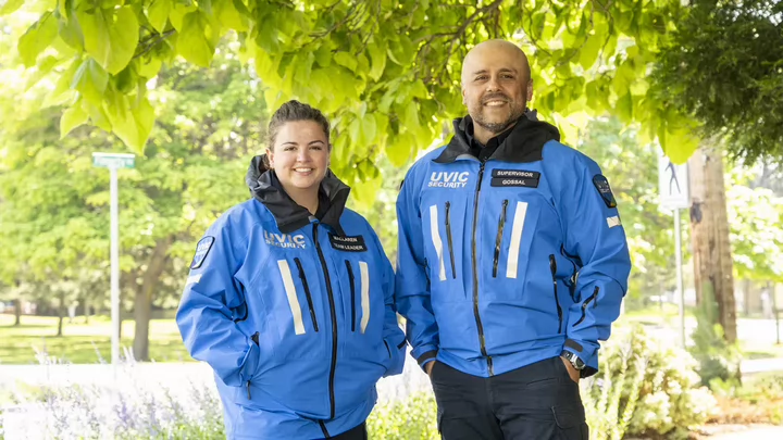 Two members of campus security in bright blue coats.