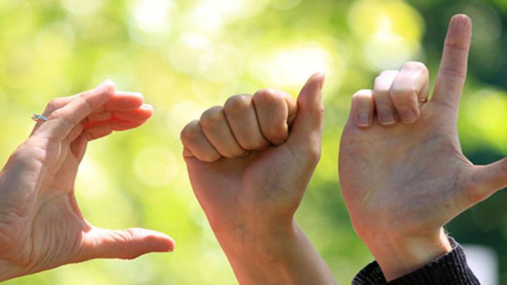 Three hands signing the letters C, A, L