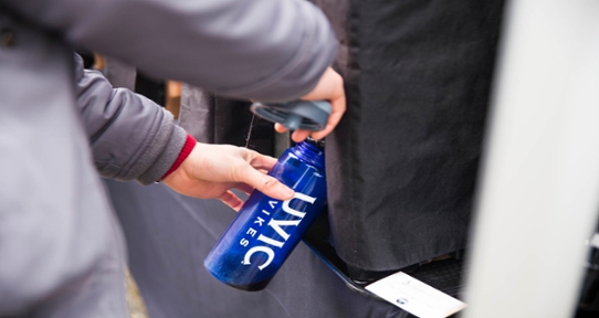 Student filling a UVic reusable water bottle at a refill station