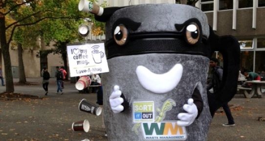 Muggo the re-usable coffee mug mascot posting next to a string of paper cups.