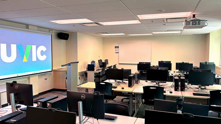 Classroom with rows of computers desks, instructor station on left side of room.
