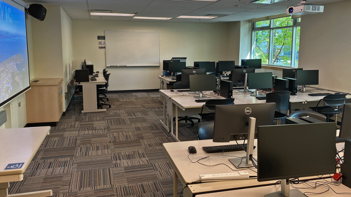 Classroom with rows of computers desks, instructor station on left side of room.