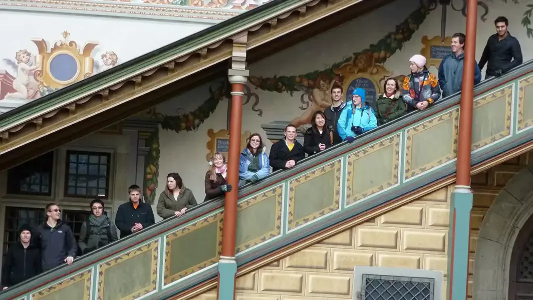 Co-op exchange students at Baden-Wuerttemberg Cooperative State University standing on an exterior covered staircase of an elaborately decorated building
