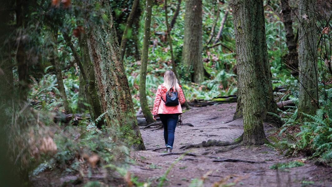 A student walks in the forest at UVic