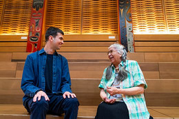 Ryder and Indigenous elder smiling in conversation in First People's House at UVic