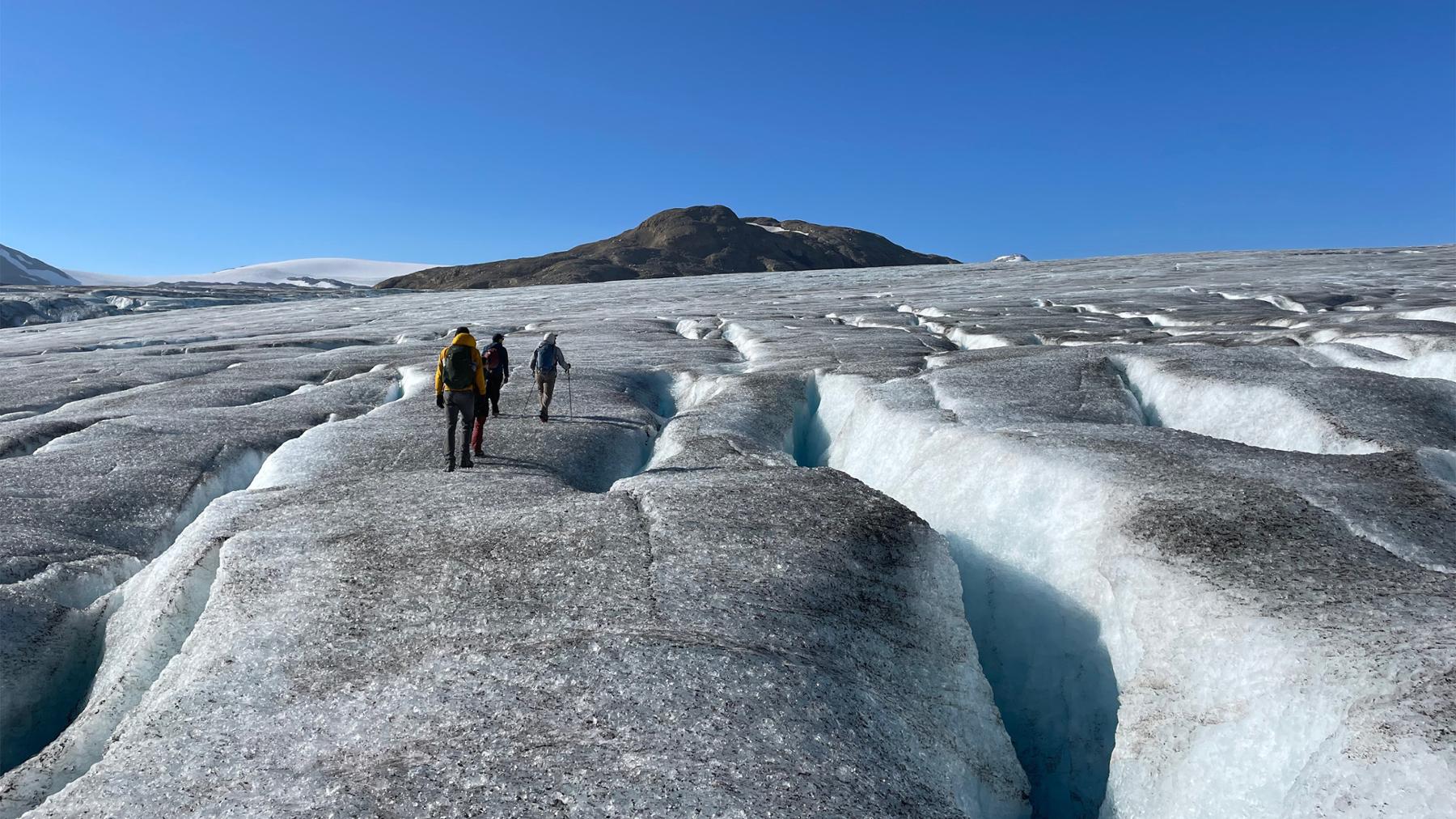 Geography students walk along glacier to track and monitor glacier displacement