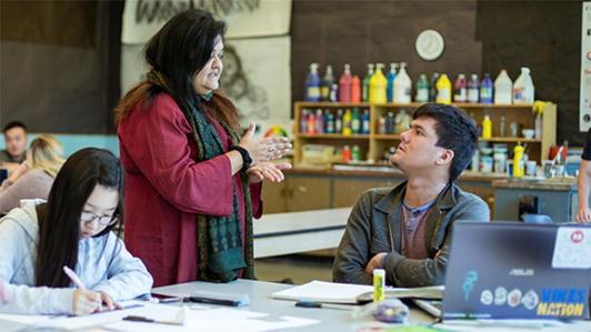 UVic faculty member speaking to a student in a classroom