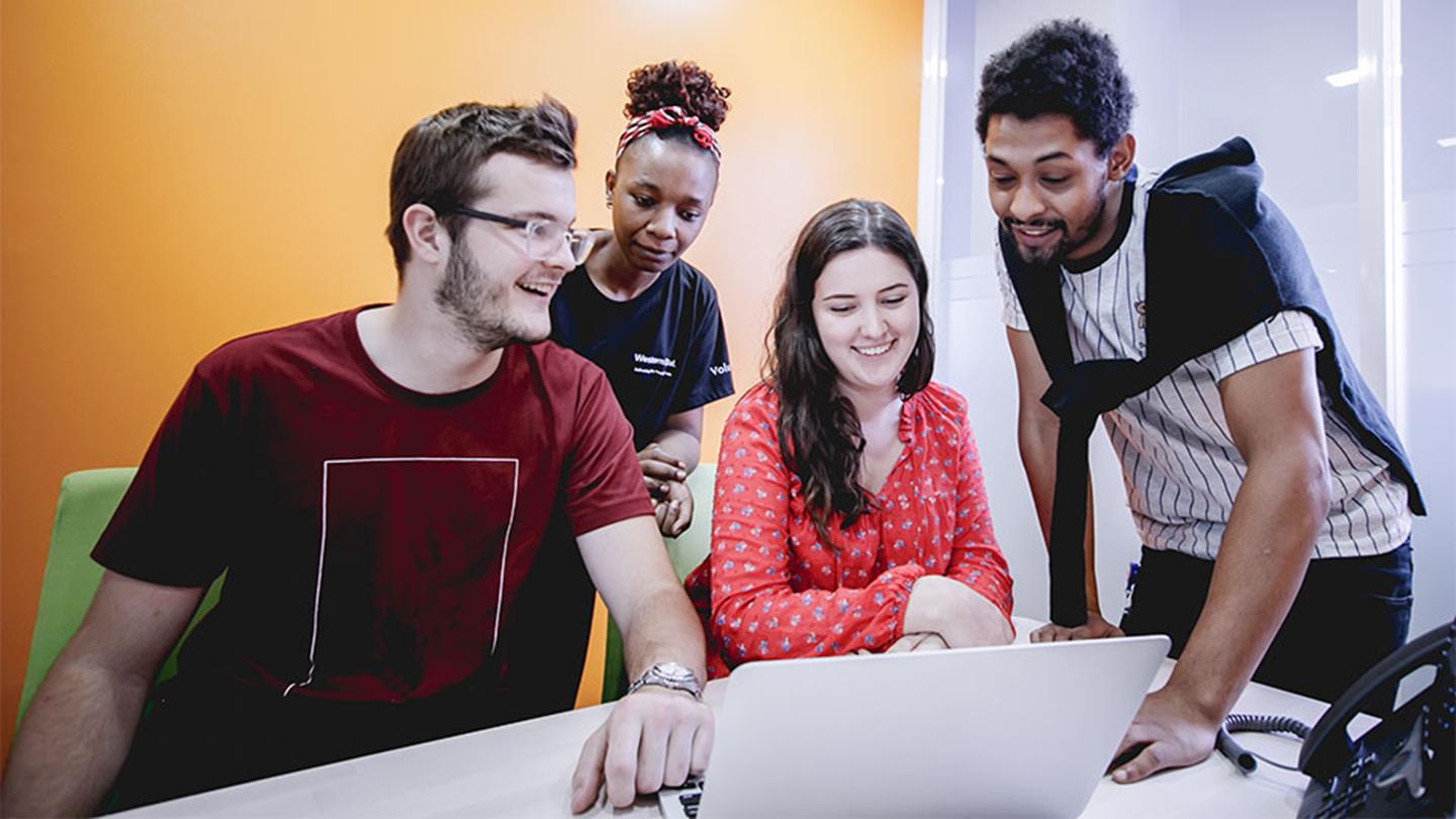 Group of UVic students looking at a laptop