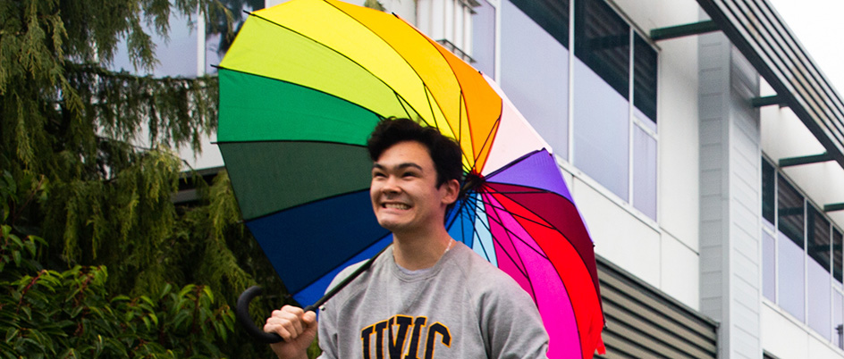 UVic student walking and holding an umbrella