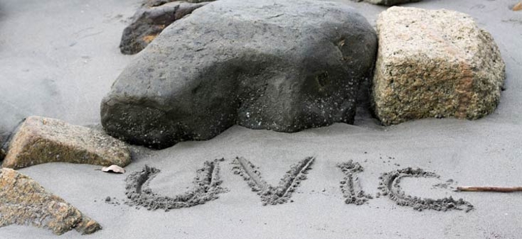 UVic written in sand on the beach