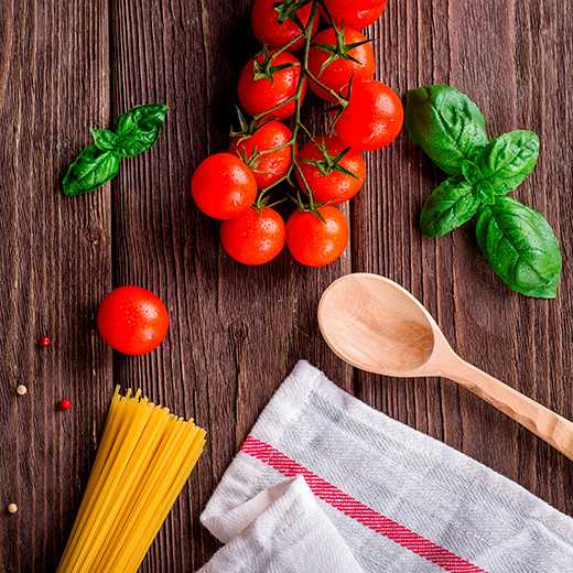 Ingredients for making pasta pomodoro on a wooden table.
